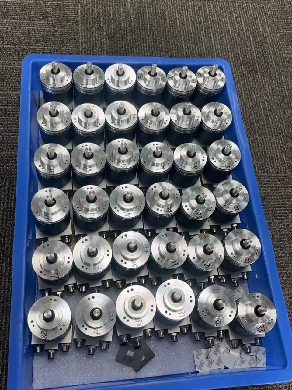 Production batch of encoders in a fixture tray — 100% factory tested